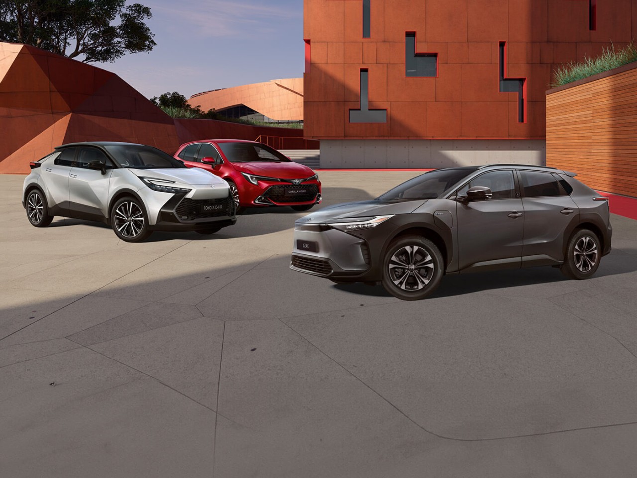 Toyota Team Deutschland Modelle stehen vor einem roten Gebäude