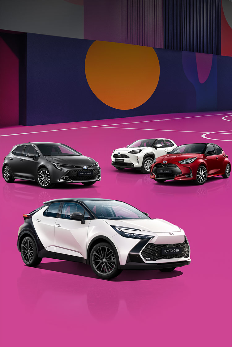 Ein weißer Toyota C-HR, ein grauer Corolla, ein weißer Yaris Cross und ein roter Yaris stehen auf einem bunten, mit lilanen, roten und blauen Mustern versehenen Basketballplatzes