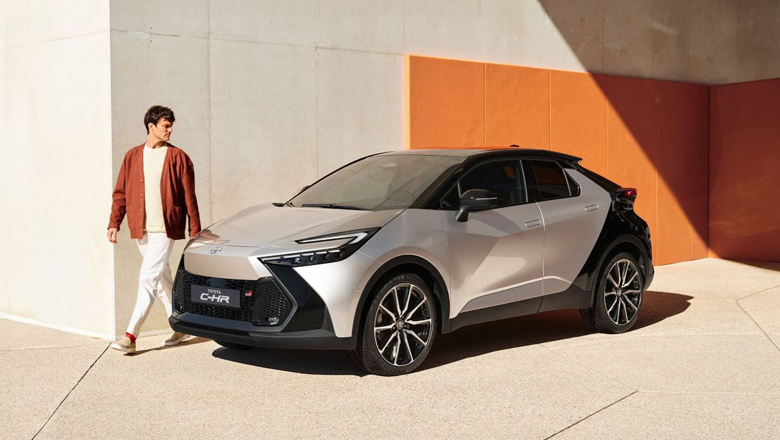 Person läuft an einem silbernen geparkten Toyota C-HR entlang.