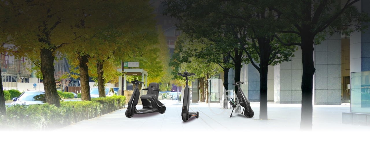 Vor dem Hintergrund einer Fußgängerzone stehen drei Elektrofahrzeuge für den Fußgängerbereich: Ein Elektromobil, ein E-Roller und ein elektrisches Rollstuhl-Zuggerät.. 